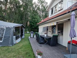 une terrasse avec une tente, une table et des chaises dans l'établissement Cozy private caravan on our lawn, à Luleå