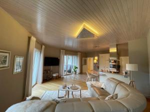 a living room with a white couch and a table at Apart Loten in Eupen