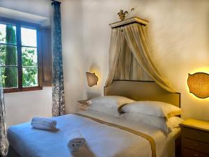um quarto com uma cama de dossel e uma janela em Villa Rignana - Chianti Weddings em Greve in Chianti