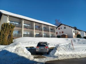 ein Auto parkt auf einem schneebedeckten Parkplatz in der Unterkunft Schöne Ferienwohnung im Südschwarzwald in Herrischried