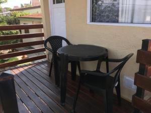 - une table noire et 2 chaises sur une terrasse couverte dans l'établissement Depto temporario carlos paz, à Villa Carlos Paz