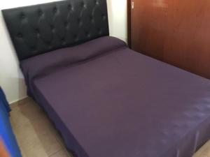 Ce lit se trouve dans un dortoir doté de draps violets. dans l'établissement Depto temporario carlos paz, à Villa Carlos Paz