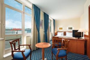 a hotel room with a bed and a desk and chairs at Ramada Prague City Centre in Prague