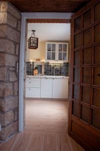 una cocina con armarios blancos y una pared de ladrillo en Maison vue sur les alignements de Carnac - Les Glycines, en Carnac