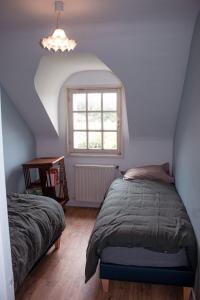 a bedroom with two beds and a window at Maison vue sur les alignements de Carnac - Les Glycines in Carnac