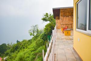 a balcony of a house with a view of a hill at La Das Treetops in Kurseong