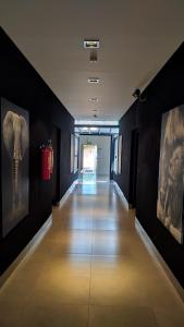 a hallway with paintings of an elephant on the wall at Hotel Barril in Primavera do Leste