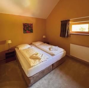 a bedroom with a bed with two towels on it at Lipno Holiday Penthouse in Lipno nad Vltavou