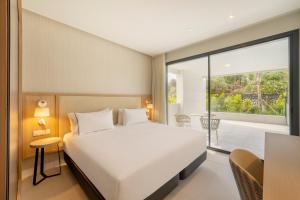 sypialnia z dużym łóżkiem i balkonem w obiekcie Eurostars Oasis Marbella w Marbelli