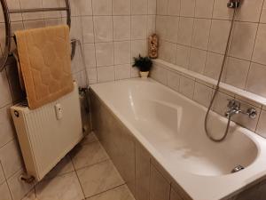 a white bath tub in a tiled bathroom at Charly's Home in Villach