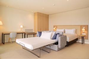 a hotel room with a bed and a couch at Eurostars Oasis Marbella in Marbella