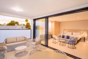 a living room with a bed and a couch and chairs at Eurostars Oasis Marbella in Marbella