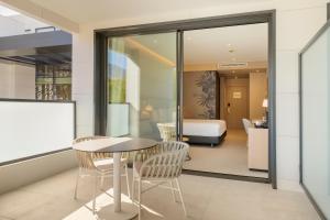 a room with a table and chairs and a bedroom at Eurostars Oasis Marbella in Marbella