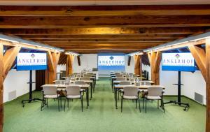 a conference room with tables and chairs and signs at Ankerhof Hotel in Halle an der Saale