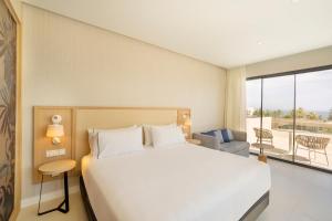 a bedroom with a large bed and a large window at Eurostars Oasis Marbella in Marbella