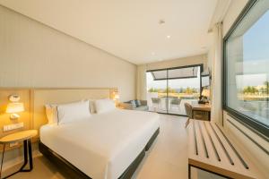 a bedroom with a white bed and a large window at Eurostars Oasis Marbella in Marbella