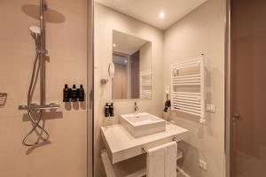a white bathroom with a sink and a mirror at Eurostars Oasis Marbella in Marbella