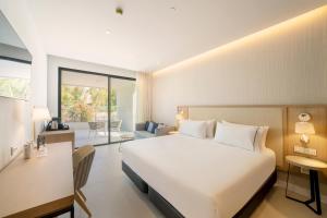 a bedroom with a large white bed and a desk at Eurostars Oasis Marbella in Marbella
