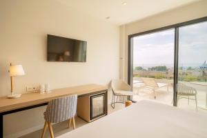 a bedroom with a bed and a desk with a fireplace at Eurostars Oasis Marbella in Marbella