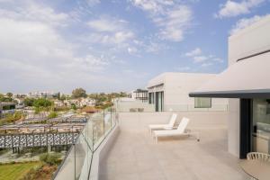 a balcony with white furniture and a view of the city at Eurostars Oasis Marbella in Marbella