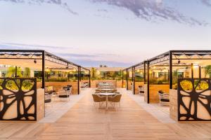 a restaurant with tables and chairs on a patio at Eurostars Oasis Marbella in Marbella