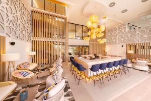 a restaurant with a bar with blue chairs and tables at Eurostars Oasis Marbella in Marbella