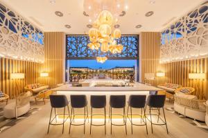 a lobby with a bar with chairs and a chandelier at Eurostars Oasis Marbella in Marbella