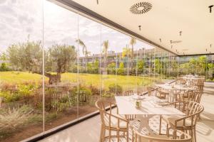 a restaurant with tables and chairs and a large window at Eurostars Oasis Marbella in Marbella