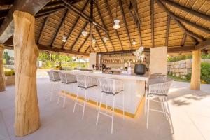 an outdoor bar with white chairs and a bar counter at Eurostars Oasis Marbella in Marbella