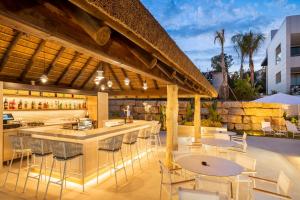 a bar with tables and chairs on a patio at Eurostars Oasis Marbella in Marbella