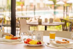 a table with two plates of food and a glass of orange juice at Eurostars Oasis Marbella in Marbella