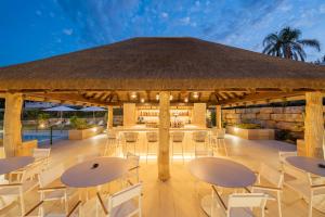 a pavilion with tables and chairs and a bar at Eurostars Oasis Marbella in Marbella