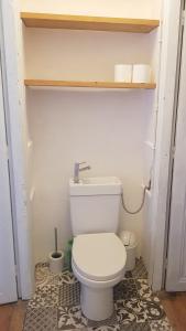 a bathroom with a white toilet in a room at Gite de l'école 