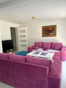 a living room with a purple couch and a table at Apartman SARA in Sarajevo