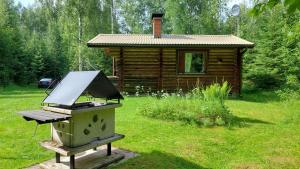 a barbecue grill in front of a log cabin at Koivula Fish Cottage in Savonlinna
