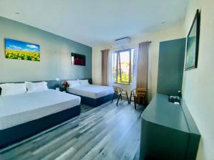 a hotel room with two beds and a table at Tam Coc Phuong Nhi Homestay in Ninh Binh