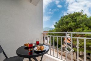 un balcón con una mesa con comida y bebidas. en A3 apt with balcony and sea view 3 min to beach, en Trogir