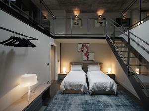 una camera con due letti e una scala di EDIT Lofts a Torino