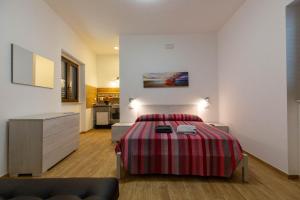 ein Schlafzimmer mit einem Bett mit einer roten und gestreiften Decke in der Unterkunft Guest House - I Salici in Elice