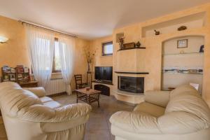 sala de estar con 2 sofás blancos y chimenea en LEONDINA COUNTRY HOUSE, en Corinaldo