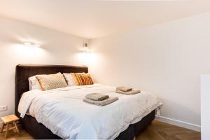 a bedroom with a bed with two towels on it at Zeezicht Villa Duin vlak bij strand en zee in Bergen aan Zee