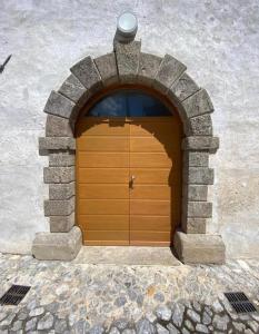drewniane drzwi garażowe w kamiennym łuku w obiekcie Cjase Cjandin w mieście Cercivento