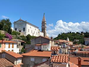 a view of a city with a church and roofs at Romantic maisonette in Piran