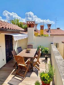 patio con mesa de madera y sillas en el balcón en Romantic maisonette, en Piran