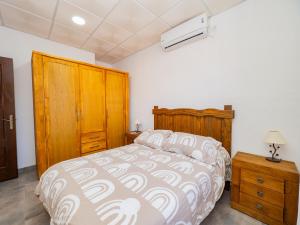 Schlafzimmer mit einem Bett und einem Holzschrank in der Unterkunft Cubo's Apto Obejo Hacienda El Encinar in Villaharta