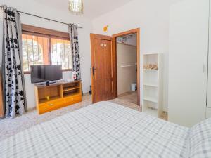Schlafzimmer mit einem Bett und einem Schrank mit einem TV in der Unterkunft Cubo's Casa Pedroche Hacienda El Encinar in Villaharta