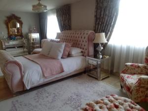 a bedroom with a bed and a chair and a window at Chateau De Vie in Krugersdorp