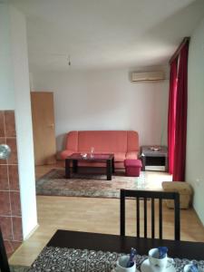 a living room with a red couch and a table at Apartman ASI in Mostar