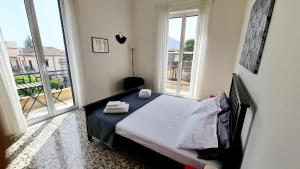 a small bedroom with a bed and a large window at Àrima Mondello Apartment in Mondello