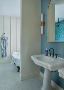 uma casa de banho branca com um lavatório e uma banheira em Hutton Brickyards Riverfront Hotel & Venue em Kingston